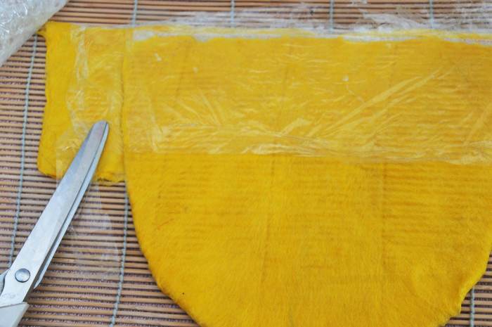 Fold the Pre-felt around the the sides of the hat. Add film to separate the layers and cover with he Pre-felt.