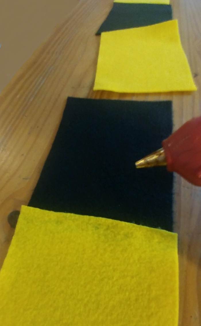 Use a glue gun to apply the glue on the edge of the felt sheets to glue together. It will dry quickly, so be sure to have in place, and press down on sheets with pressure to attach properly.