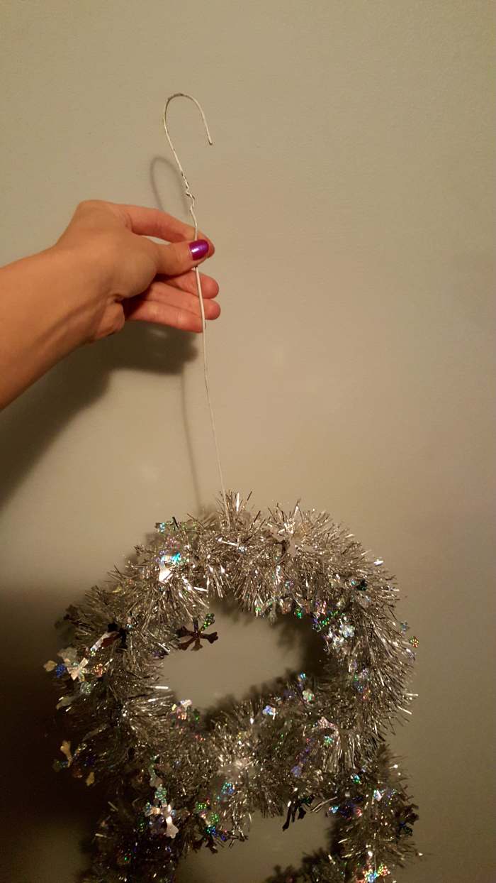 Use any left over wire hanger pieces to create a hook. Or create a hook using your floral wire. Attach to the middle of your top circle to hang your snowman.
