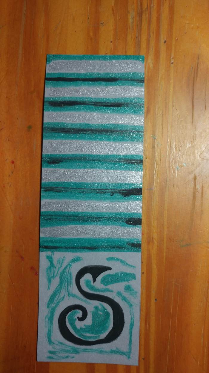 Apply green where needed, on lines and around snake. Fill in empty lines with silver marker. It may be a glitter or shiny silver marker.