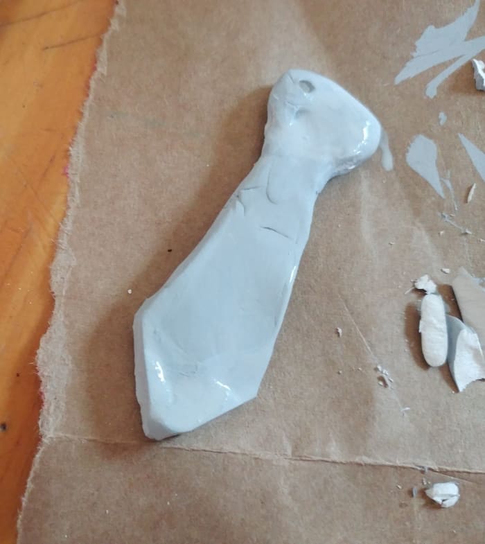 Use Polymer clay to shape the tie. You may use colored Polymer clay to match house color of your choice.