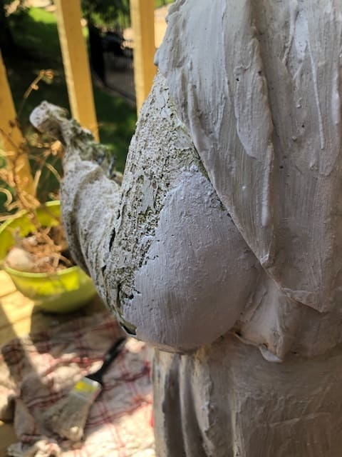 The difference between an area with no plaster and an area that has been filled in with plaster on a statue.