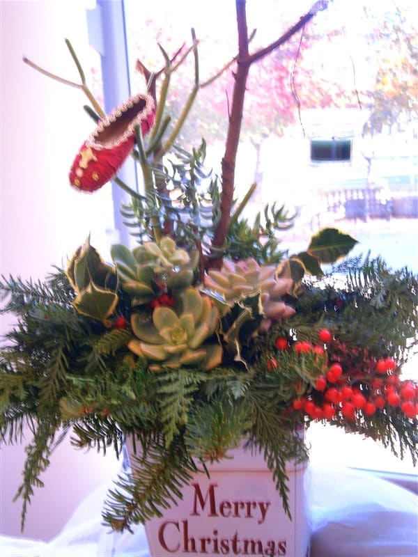 Add an accent ornament to your piece. I use a ballet slipper to give this centerpiece some character. The total cost spent on this centerpiece is ($6.97 ($2.99 for container, $1 for floral foam and 99 cents for votive, $1.99 for slipper)