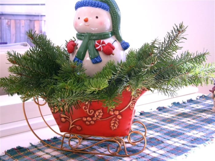 Free noble fir, snowman tealight--$5.99, floral foam--$1 and sleigh--free--given by a good friend (thank God for them). Total: $6.99