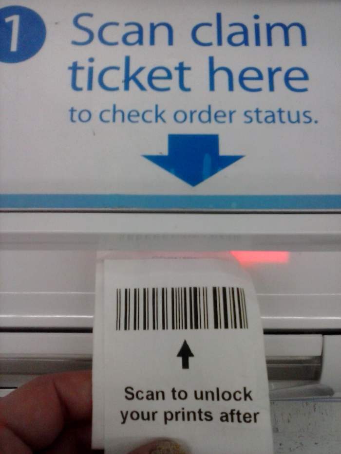 At the kiosk, they have a scanner; you scan your ticket's barcode, and it will beep. The screen will tell you they are retrieving your order. There's a small door below to open and get your prints.
