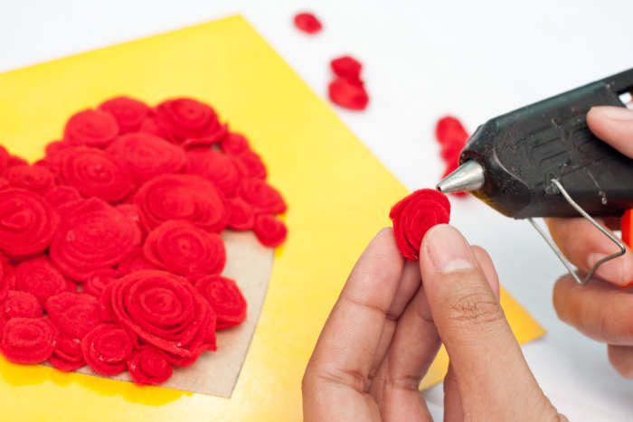 Step 8: Cover your heart pattern with the red roses and glue them into place with hot glue. Shape them so they look like the roses in the picture