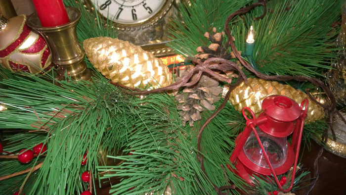 An evergreen garland with golden pine cones flanked by antique barbed wire that was out behind the barn and tiny lanterns purchased from the local dollar store.