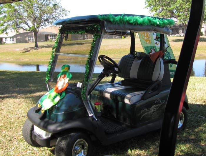 Shimmering green festoons the top of this cart and a rollicking leprechaun cavorts on the front. Make sure that you don't obstruct the driver's view. Safety first. A yard banner flutters from the back.