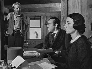 A deep focus shot showing all the actors from the near foreground to outside the window in sharp focus.