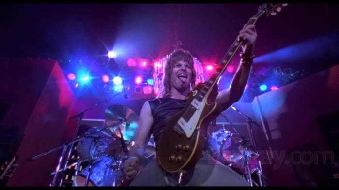 The film pierces the insanity and pomposity of rock band documentaries and performances like a safety pin to a balloon.