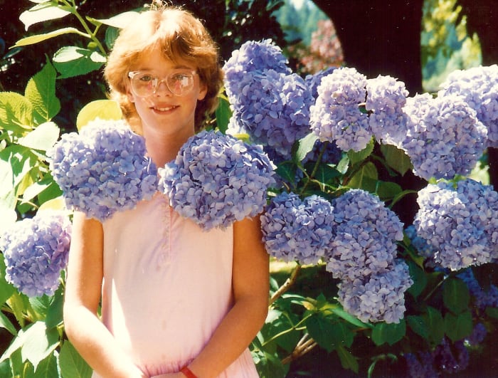 My beautiful niece with the amazingly bountiful hydrangeas in bloom on the grounds of the Capilano Suspension Bridge Park