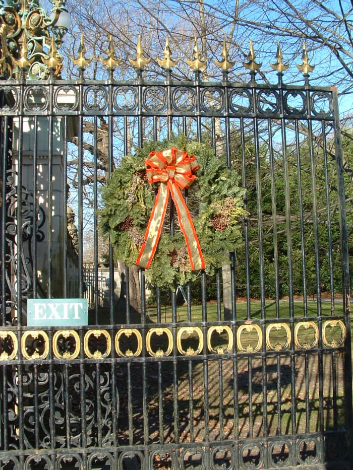 One of the iron gates marking the circular driveway, decorated with a large wreath for Christmas.