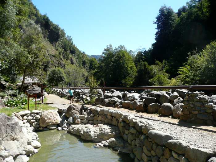 The natural appearance of the hot springs is retained at the Termas de Los Pozones. The river is beyond the built up wall.