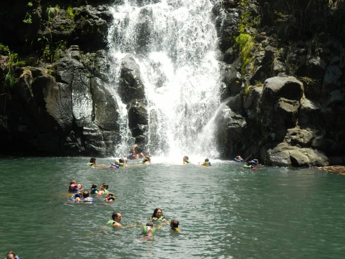 Waimea Falls. Visitors are welcome to take a dip at the foot of the waterfall while in Waimea Valley.