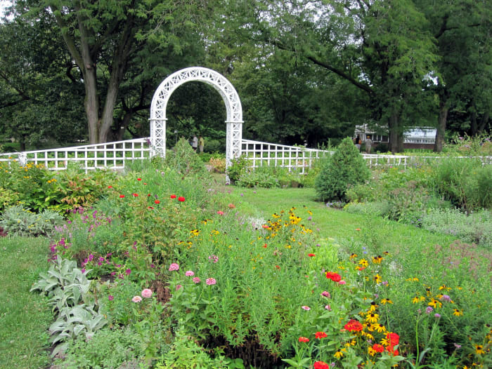 Landscape architect O.C. Simonds designed the formal garden in 1910. The greenhouse, circa 1915, is visible in the back right of the photo.