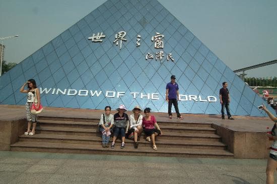 A family enjoying a day out at Window of the World, Shenzhen, South China. That's a replica of the Louvre, Paris, France in the background.