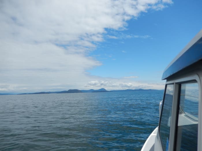 View across Rosaio Strait from a small cruiser heading toward islands and on to Friday Harbor. Notice how thespectacular sky--half cloudy and half blue--is reflected in the sea.
