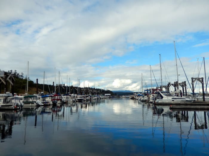 The lines of privately owned boats--in this case, C-Dories on the left, large yachts on the right--are highlighted by the flat, barely rippled water reflecting the vivid sky over Friday Harbor Marina.