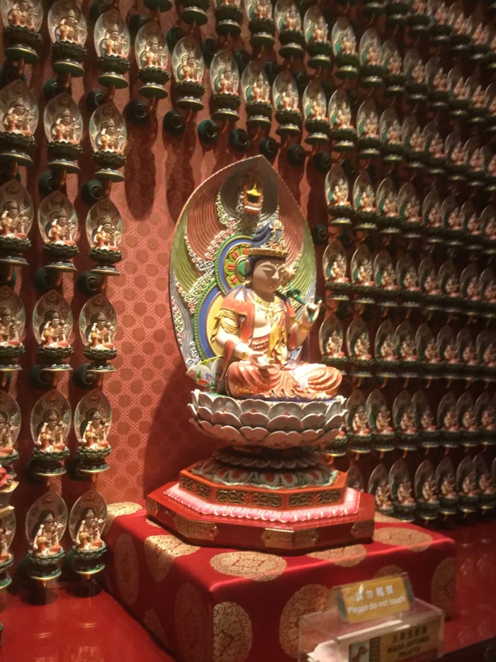 One hundred Buddha statues line this wall on the first floor of the Buddha Tooth Relic Temple. Each individual statue has a name and a specific hand sign, called a mudra.