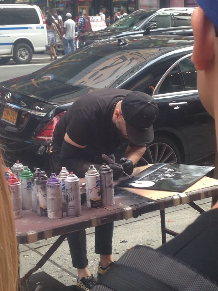 Looking for cool things to do in NYC? Look no further than one of the city's many street artists like this one using spray paint to make a painting
