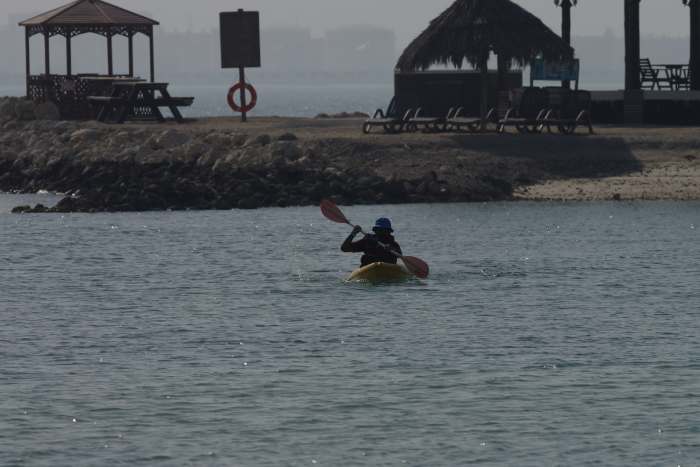 My younger brother pedals his kayak from quite far off in the waters back to our picnic spot (April 2016).