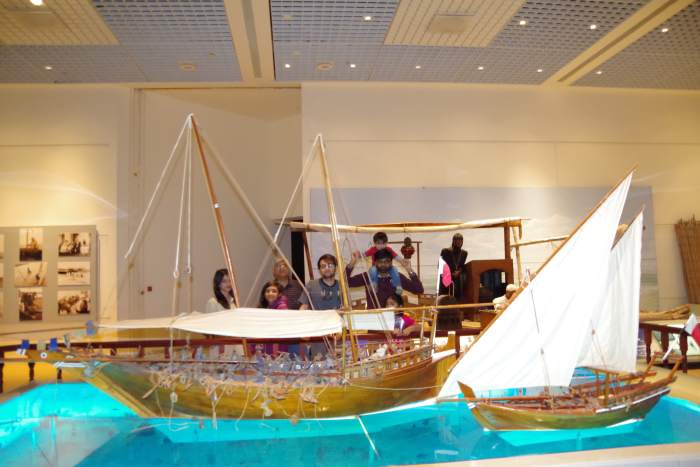 Some members of the entourage are watching traditional ships (dhows) sailing over the gulf waters.