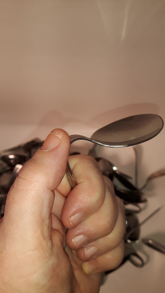 After a few minutes, gently push on the bowl of the spoon to see if it is ready to bend.