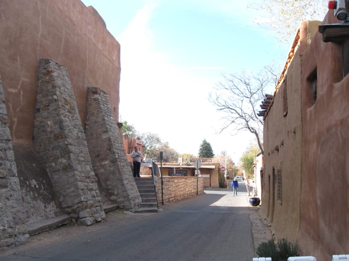 Looking down de Vargas St with Oldest House on the right and rear side of San Miguel Church on the left