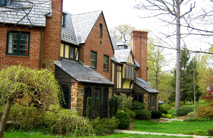 Slate roofs and varied building materials including half timbering in a beautifully landscaped setting.