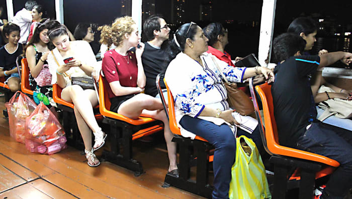 Thais and foreigners - known as 'farangs' - return from the night market and restaurant complex of Asiatique, on one of the Chao Phraya Express River Boats