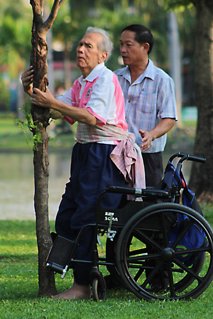 For a long time I watched as this disabled, elderly gentleman was helped to exercise by members of his family in Chatuchak Park. Their devotion to helping him stand and walk was considerable and touching