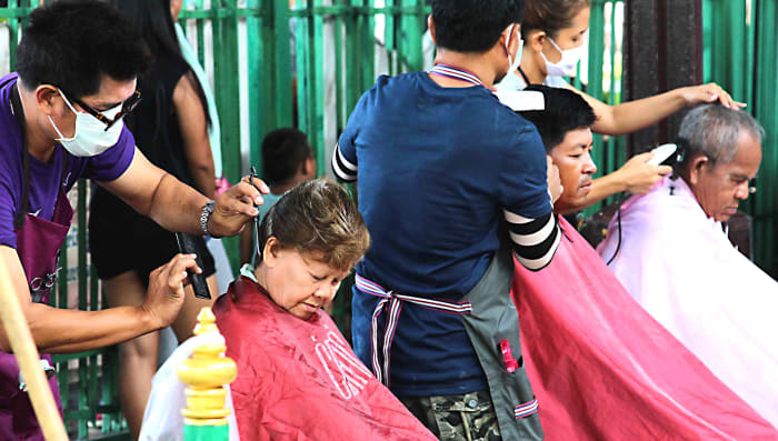 Open air hairdressing at Hua Lamphong Train Station, photographed on the platform of Bangkok's main nationwide terminus