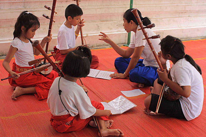 School children rehearse traditional Thai instruments during a music lesson in the grounds of the Wat Arun temple