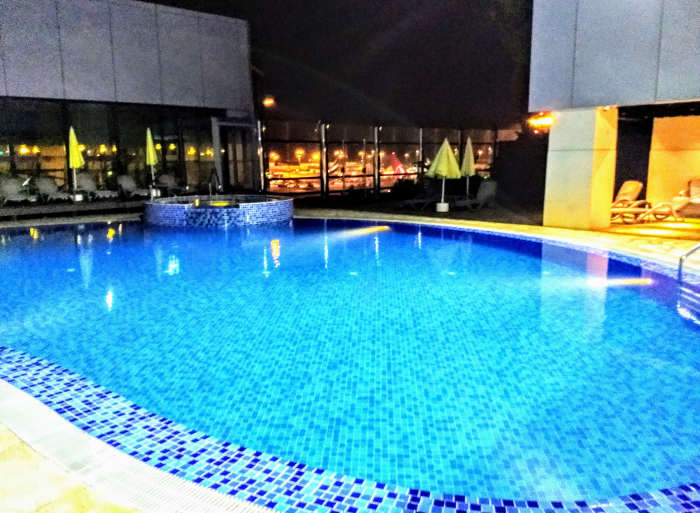 The only transit hotel in Asia with an outdoor swimming pool. Note the lights of the tarmac between the two buildings.