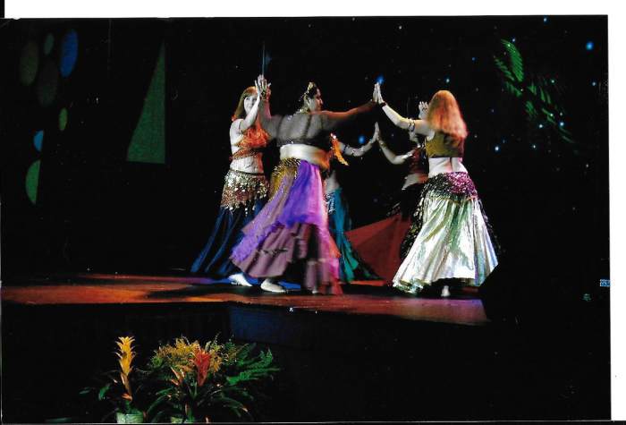 Belly dancers are having fun performing before an audience while continuing their aerobic exercises.