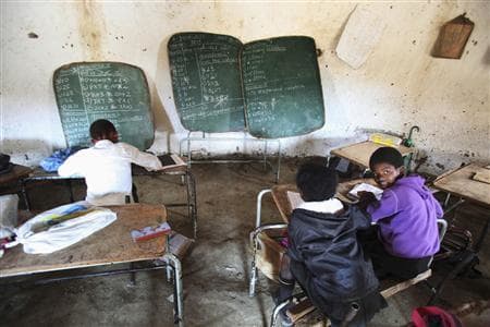 Children write notes from a makeshift blackboard at a school in Mwezeni village in South Africa's Eastern Cape Province in this picture taken June 5, 2012.
