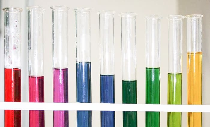 Red cabbage juice colours at different pH values. From left to right, the pH numbers are 1, 3, 5, 7, 8, 9, 10, 11, and 13. The juice looks violet at pH 7, despite its appearance in this photo.