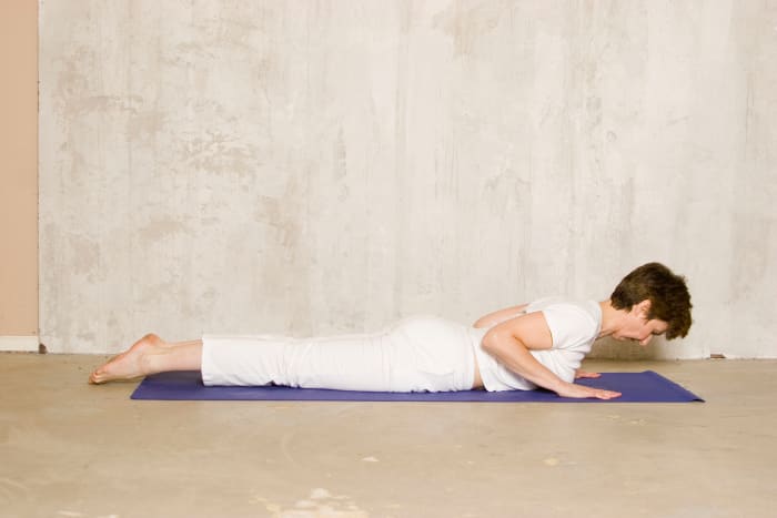 Reach forward and up through the top of the head to lengthen the spine as you come into Cobra. Use the back and abdominal muscles to lift the upper body off the floor, not the arms. Arch between the shoulder blades, not in the lower back.