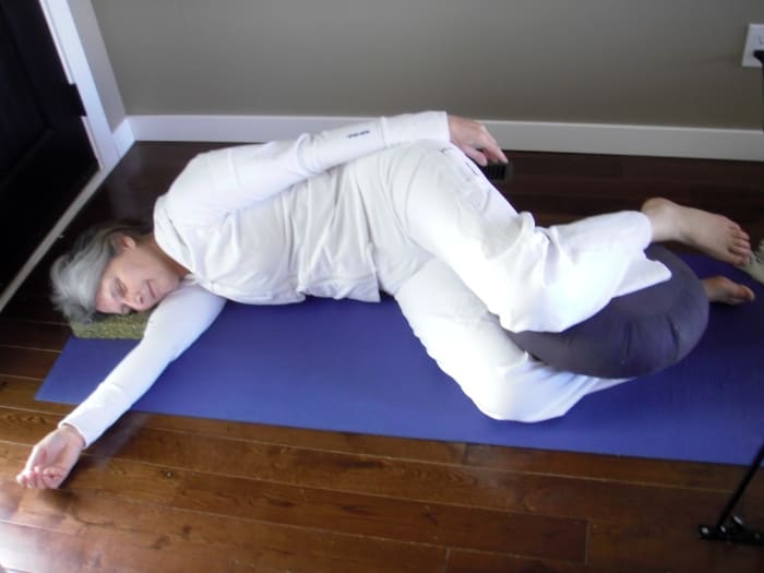 Lie on the side for final relaxation. Use bolsters or cushions under the head and between the legs, or use a body pillow. Cover yourself with a blanket to stay warm.
