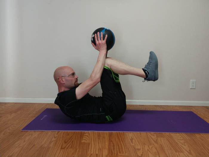 Once your knees have touched the ball, extend back to starting position and repeat, keeping your feet and hands about 6 inches off the floor.