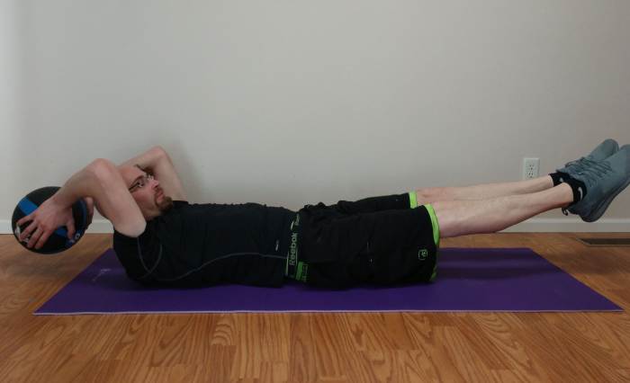 To do a full extension with a medicine ball, bring your knees up to your chest and the medicine ball up to your knees