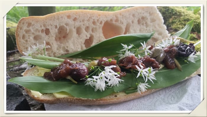 A sourdough baguette filled with wild garlic leaves and flowers, pickled wild garlic buds, wild plum sauce, and a few olives.