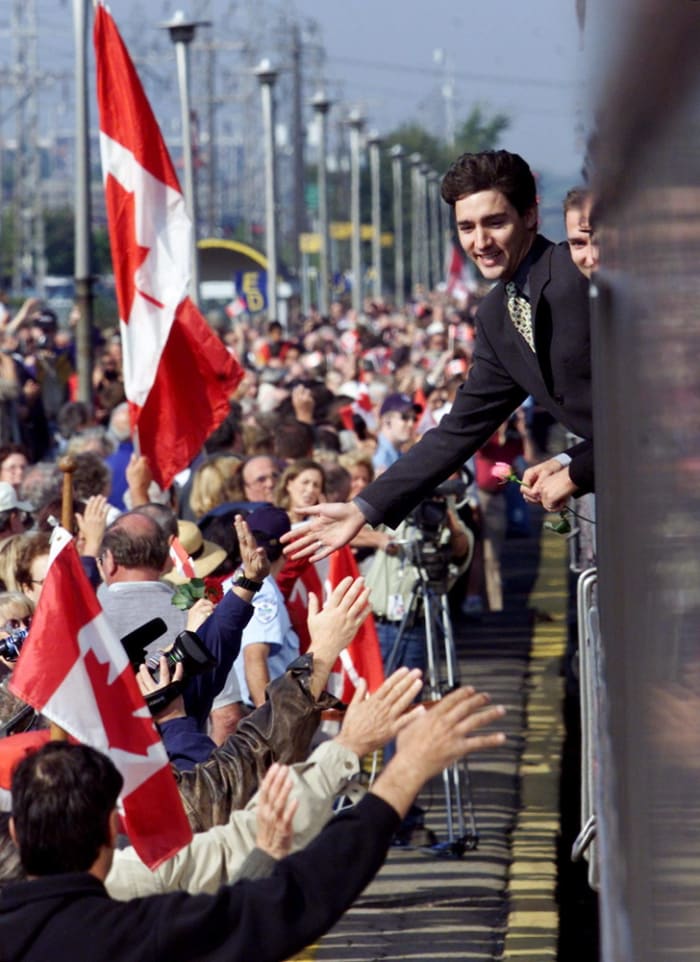 Justin and Alexandre (Sacha) Trudeau lean out of the funeral train to show appreciation to mourners who turned out to pay their respects to former prime minister Pierre Trudeau in Dorval, Quebec (Oct 2, 2000).