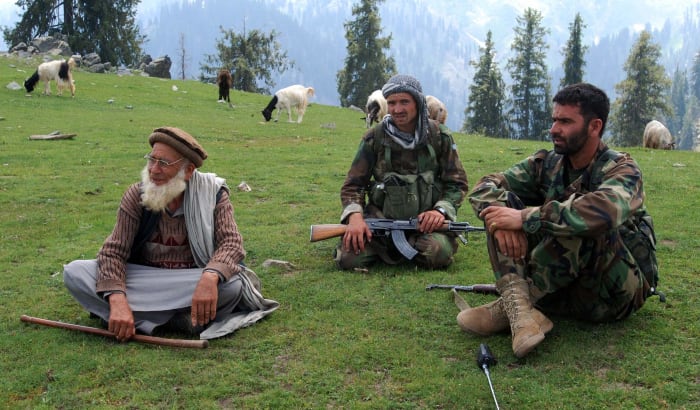 Two Afghan National Army Soldiers talk with a local Afghan during Operation Saray