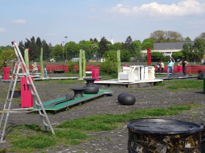 A mini-golf play area, created from scrap metal and sited where once planes parked, sits beneath the minarets, behind the Tempelhofer Feld.