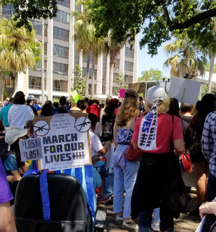 The sign on this wheelchair says, $1.05. That equals the amount of NRA lobbying money received by Senator Rubio. When divided by the number of students in the state of Florida, it comes to $1.05 per student.
