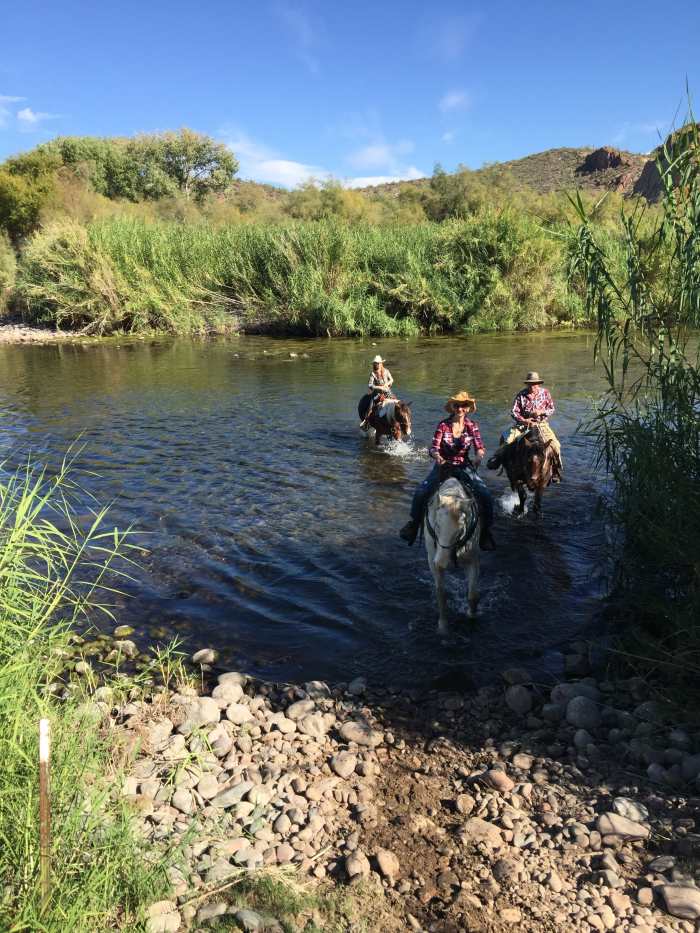 My Wife and I With Trail Guide Crossing Salt River on Horseback. Visited Saguaro Lake Ranch Stables which provides horses and guides for trail rides along Salt River.