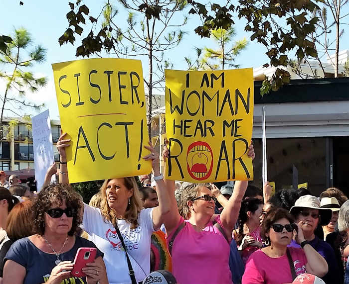 Sisterhood was a popular theme at the rally and marches. These signs say "Sister Act" and "I Am Woman, Hear Me Roar." The last one is the title of a song by Helen Reddy.