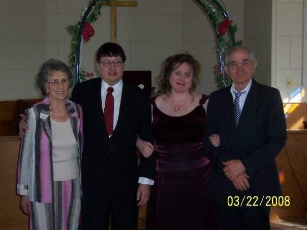This is a photo of my Grandma, on the left hand side, with my husband, me, and my Grandpa. (at our wedding)