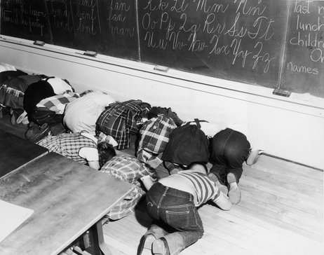 If you couldn't get under something, you were to duck away from windows, up against and inside wall, and cover the back of your neck and face to keep from getting burned by the radiation.